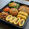 Bibimbap / Japche,  Stir fried Tofu, Korean egg roll / Sautéed Veg, Korean Veg, Kimchi, Honey sweet potato, Leafy salad